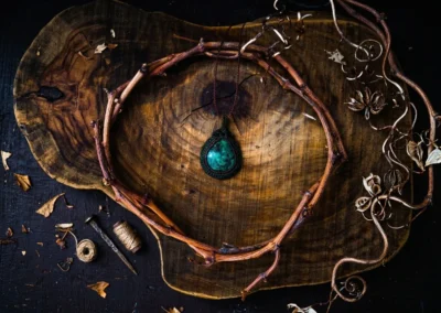 Colgante artesanal con una piedra oscura brillante enmarcado por una corona de ramas de madera